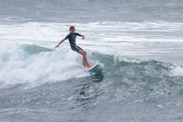 TENERIFE, SPAIN, NOVEMBER-03-2013: çocuk sörf yarışmasında sörf yapıyor, dalganın duvarında birkaç harika manevra yapıyor. Tenerife, Kanarya Adaları, İspanya