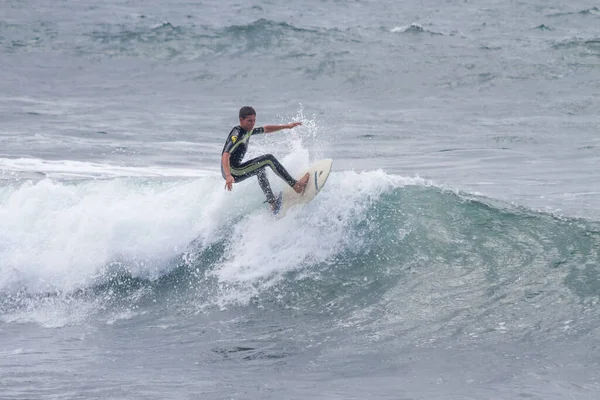 TENERIFE, SPAIN, NOVEMBER-03-2013: çocuk sörf yarışmasında sörf yapıyor, dalganın duvarında birkaç harika manevra yapıyor. Tenerife, Kanarya Adaları, İspanya