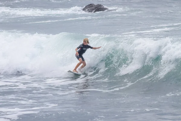 TENERIFE, SPAIN, NOVEMBER-03-2013: çocuk sörf yarışmasında sörf yapıyor, dalganın duvarında birkaç harika manevra yapıyor. Tenerife, Kanarya Adaları, İspanya