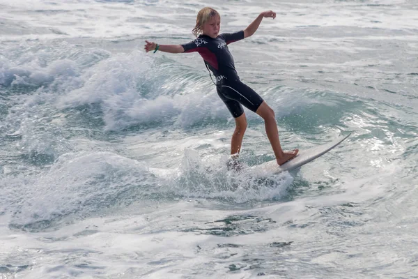 TENERIFE, SPAIN, NOVEMBER-03-2013: çocuk sörf yarışmasında sörf yapıyor, dalganın duvarında birkaç harika manevra yapıyor. Tenerife, Kanarya Adaları, İspanya