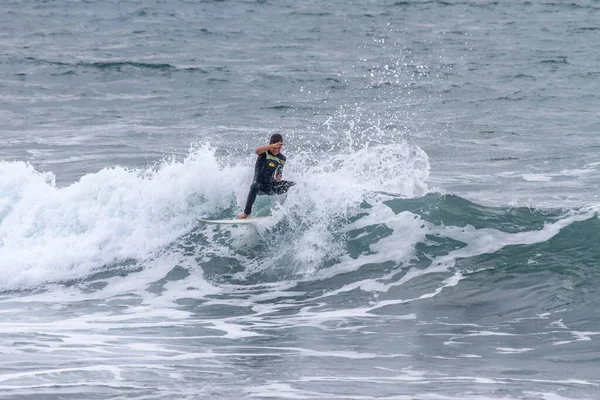 TENERIFE, SPAIN, NOVEMBER-03-2013: çocuk sörf yarışmasında sörf yapıyor, dalganın duvarında birkaç harika manevra yapıyor. Tenerife, Kanarya Adaları, İspanya