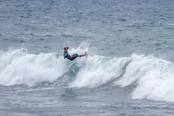 TENERIFE, SPAIN, NOVEMBER-03-2013: çocuk sörf yarışmasında sörf yapıyor, dalganın duvarında birkaç harika manevra yapıyor. Tenerife, Kanarya Adaları, İspanya