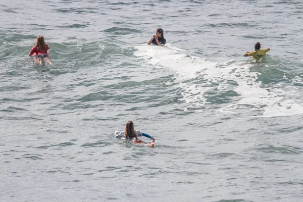 TENERIFE, SPAIN, NOVEMBER-03-2013: Sörf yarışmasında sörf yapmak ve yarışmak için dalgaların gelmesini bekleyen dört kız. Tenerife, Kanarya Adaları, İspanya
