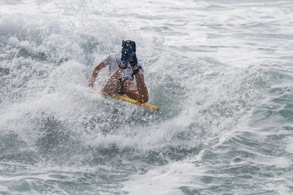 TENERIFE, SPAIN, NOVEMBER-03-2013: Sörfçü kız bir yarışmada, beyaz köpüklü sörf tahtası ile çeşitli manevralar yapar. Tenerife, Kanarya Adaları, İspanya