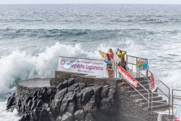TENERIFE, SPAIN, NOVEMBER-03-2013: sörf tahtaları olan dört sörfçü kız, sörf yapmak ve yarışmak için bir dalgakırandan denize bakın. Tenerife, Kanarya Adaları, İspanya