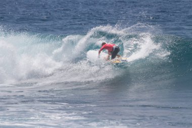 TENERIFE, SPAIN 11 - HAZİRAN 2013: Erkekler vücut tahtası şampiyonasında yarışan bir çocuğun dalgada dizlerinin üzerinde sörf yaparken farklı ve inanılmaz manevralar ve dönüşler yaparak bir sürü köpük oluşturduğu açık çekim. Tenerife, Kanarya Adaları, İspanya