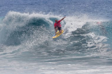 TENERIFE, SPAIN 11 - HAZİRAN 2013: Erkekler vücut tahtası şampiyonasında yarışan bir çocuğun dalgada dizlerinin üzerinde sörf yaparken farklı ve inanılmaz manevralar ve dönüşler yaparak bir sürü köpük oluşturduğu açık çekim. Tenerife, Kanarya Adaları, Spai