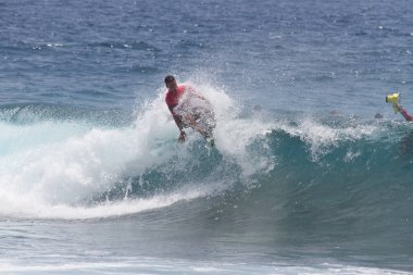 TENERIFE, SPAIN 11 - HAZİRAN 2013: Erkekler vücut tahtası şampiyonasında yarışan bir çocuğun dalgada dizlerinin üzerinde sörf yaparken farklı ve inanılmaz manevralar ve dönüşler yaparak bir sürü köpük oluşturduğu açık çekim. Tenerife, Kanarya Adaları, Spai