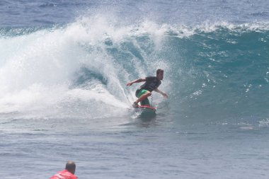 TENERIFE, SPAIN 11 - HAZİRAN 2013: Erkekler vücut tahtası şampiyonasında yarışan bir çocuğun dalgada dizlerinin üzerinde sörf yaparken farklı ve inanılmaz manevralar ve dönüşler yaparak bir sürü köpük oluşturduğu açık çekim. Tenerife, Kanarya Adaları, Spai