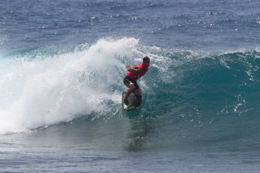 TENERIFE, SPAIN 11 - HAZİRAN 2013: Erkekler vücut tahtası şampiyonasında yarışan bir çocuğun dalgada dizlerinin üzerinde sörf yaparken farklı ve inanılmaz manevralar ve dönüşler yaparak bir sürü köpük oluşturduğu açık çekim. Tenerife, Kanarya Adaları, Spai