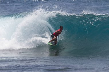 TENERIFE, SPAIN 11 - HAZİRAN 2013: Erkekler vücut tahtası şampiyonasında yarışan bir çocuğun dalgada dizlerinin üzerinde sörf yaparken farklı ve inanılmaz manevralar ve dönüşler yaparak bir sürü köpük oluşturduğu açık çekim. Tenerife, Kanarya Adaları, Spai