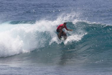 TENERIFE, SPAIN 11 - HAZİRAN 2013: Erkekler vücut tahtası şampiyonasında yarışan bir çocuğun dalgada dizlerinin üzerinde sörf yaparken farklı ve inanılmaz manevralar ve dönüşler yaparak bir sürü köpük oluşturduğu açık çekim. Tenerife, Kanarya Adaları, Spai