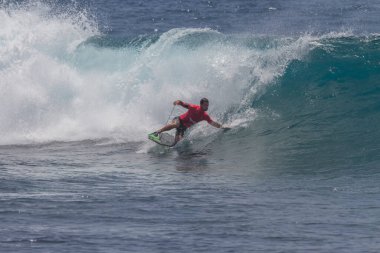 TENERIFE, SPAIN 11 - HAZİRAN 2013: Erkekler vücut tahtası şampiyonasında yarışan bir çocuğun dalgada dizlerinin üzerinde sörf yaparken farklı ve inanılmaz manevralar ve dönüşler yaparak bir sürü köpük oluşturduğu açık çekim. Tenerife, Kanarya Adaları, Spai