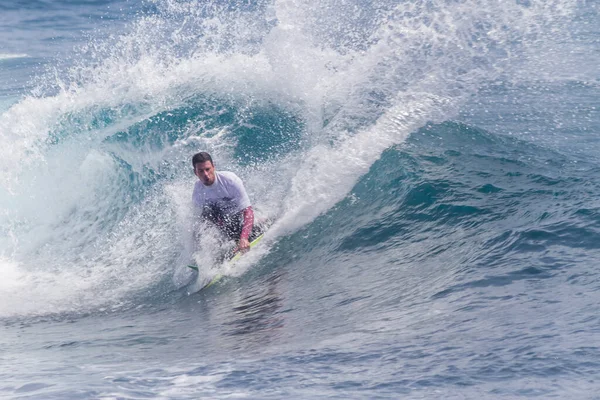 TENERIFE, SPAIN 11 - HAZİRAN 2013: Erkekler vücut tahtası şampiyonasında yarışan bir çocuğun dalgada dizlerinin üzerinde sörf yaparken farklı ve inanılmaz manevralar ve dönüşler yaparak bir sürü köpük oluşturduğu açık çekim. Tenerife, Kanarya Adaları, İspanya