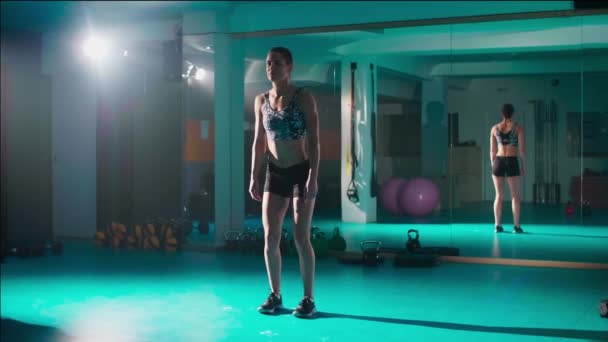 Μια Νεαρή Γυναίκα Τεντώνεται Στο Γυμναστήριο Μέσα Από Μια Άσκηση — Αρχείο Βίντεο