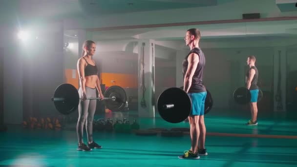남녀가 훈련하면서 동시에 체육관에서 리프트 운동을 — 비디오