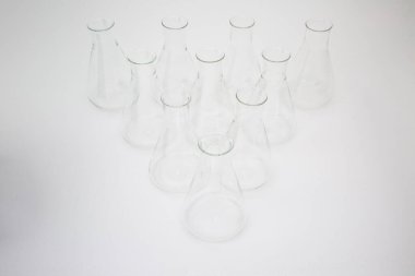Beyaz arka planda izole edilmiş bir grup bilimsel cam Erlenmeyer şişesi.
