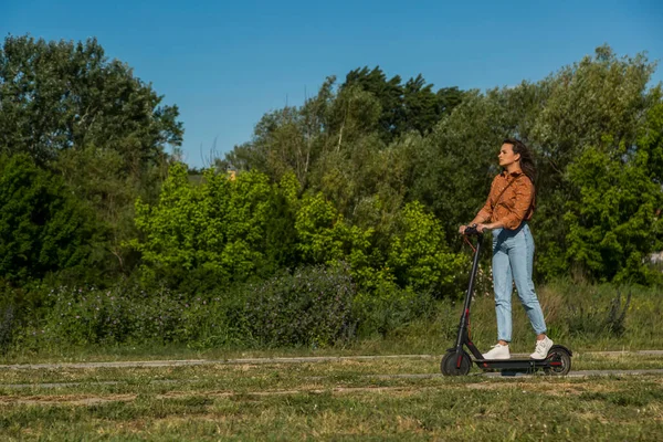 Fiatal Gyönyörű Lány Lovagol Egy Elektromos Robogó Keresztül Park Zöld — Stock Fotó