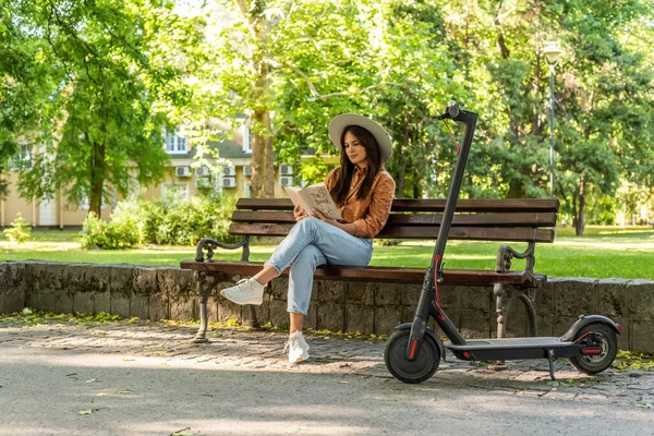 Молода Красива Дівчина Капелюхом Сидить Лавці Парку Читаючи Книгу Електричний — стокове фото