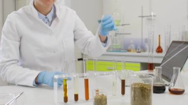 Laboratuvarda kenevir CBD ve CBDA yağı ile çalışan kimya bilimcilerini kapatın. Erlenmeyer matarası kullanıyor. Esrar eczacılık sağlık hizmeti kavramı.