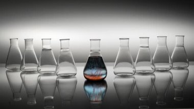 Çemberde karıştırılmış renkli kimyasal sıvıyla Erlenmeyer şişesi