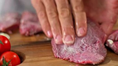 Aşçının ellerinin, tereyağını sürdüğü ve bir parça ete başka baharatlar kattığı hazırlık aşamasında yakın plan çekimi..