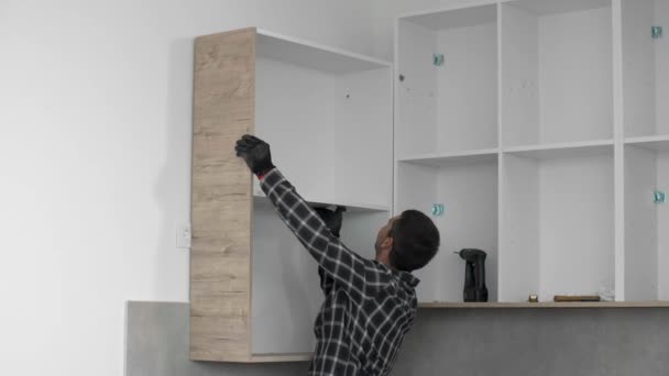 木匠把新组装的厨房架子放在预定的地方 — 图库视频影像