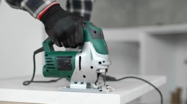 Marangozun mutfak elementinde delikler açtığı bir yapbozun yakın çekimi ve ahşap bir atölye..