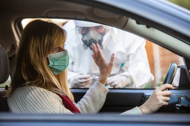 Kadın sürüş sırasında COVID 19 testi yapmayı reddediyor. Hastanın burnundan araba camından DNA örneği alıyor. PCR teşhisi koyuyor. Pasaportları var..