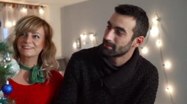 Bir çift oturma odasında Noel ağacı süslemekten zevk alıyor. Tatil hazırlığı.