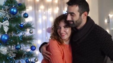 Bir çift oturma odasında Noel ağacı süslemekten zevk alıyor. Tatil hazırlığı.