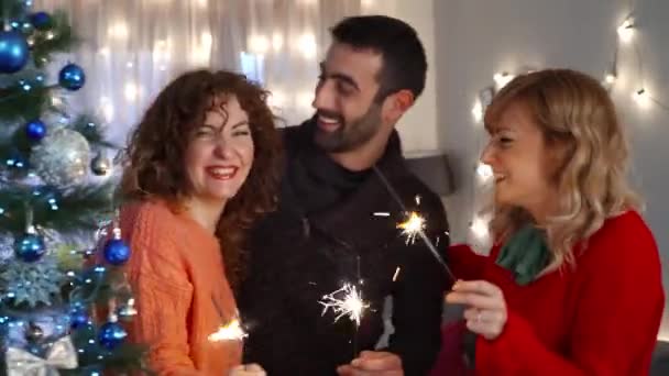 Glada Vänner Håller Sprinklers Vid Julgranen Nyårsafton Firar Och Ler — Stockvideo