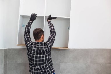 Marangoz, yeni monte edilen mutfak raflarını....