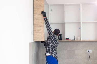 Marangoz, yeni monte edilen mutfak raflarını....