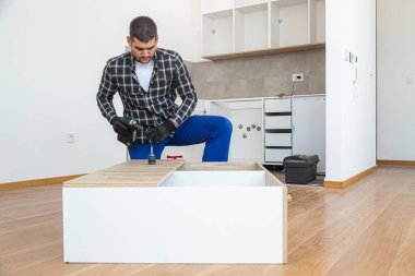 Marangoz mutfak rafının montajını bitiriyor..