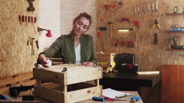 车间里的女木匠 测量一个木箱 看她的工作图纸 — 图库视频影像