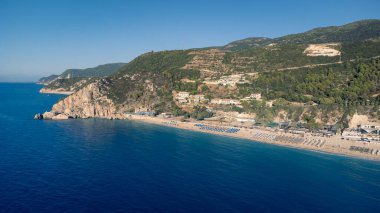 Güneş gözlüklü ve yumuşak turkuaz okyanus dalgalı güzel kumlu sahil manzarası. Yaz mevsiminde Lefkada adasındaki Kathisma plajında tropik deniz..