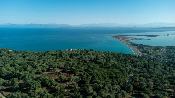 Yunanistan 'ın Lefkada adasındaki Agios Ioannis plajının hava manzarası. Önünde zeytin ağaçları ve uzakta da anakara var..