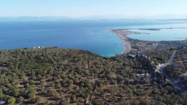 Yunanistan 'ın Lefkada adasındaki Agios Ioannis plajının hava manzarası. Önünde zeytin ağaçları ve uzakta da anakara var..