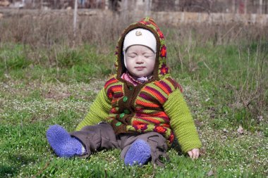 child in bright clothes in the sun blinks clipart