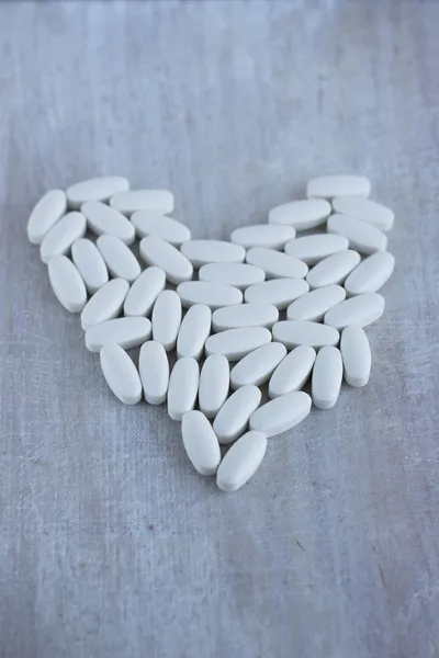 The heart of the white oval tablets — Stock Photo, Image