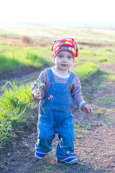 Pretty child in the red headscarf and jeans overall — Stock Photo, Image