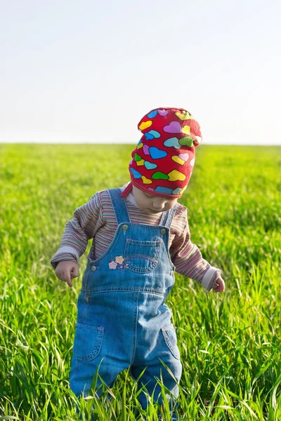 Little girl in the red bandana in the middle rich grass — Stock Photo, Image