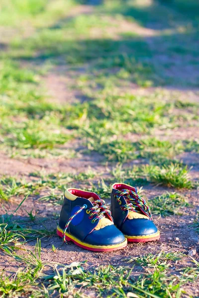 Botas de bebê na estrada de terra — Fotografia de Stock