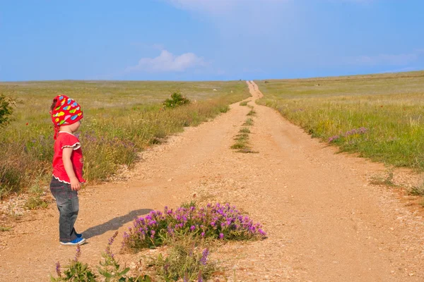 Meisje door onverharde weg — Stockfoto