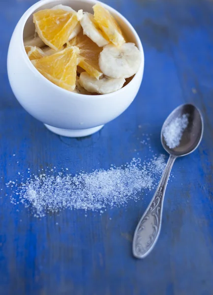 Bananas and orange on the china dish and spoon sudars — Stock Photo, Image