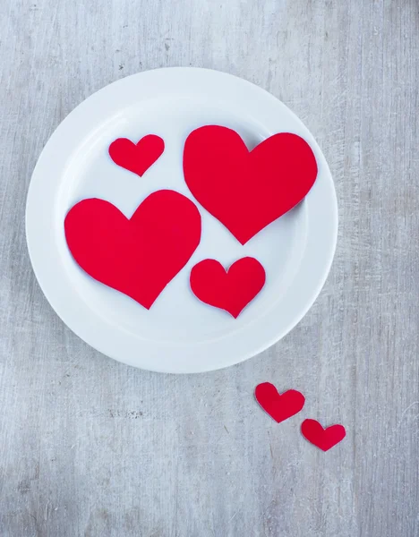 Corazones grandes y pequeños en la placa redonda blanca — Foto de Stock