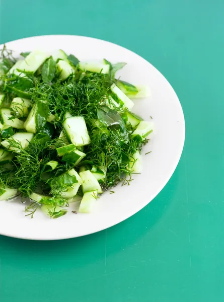 salatalık salatası yeşil kağıt üzerinde yuvarlak beyaz tabak