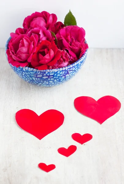 Сердца и много красной розы в голубой тарелке — стоковое фото