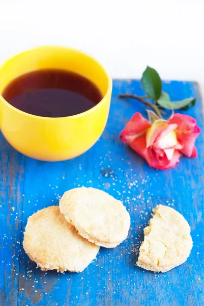 Shortbread, xícara amarela com chá forte e rosa rosa — Fotografia de Stock